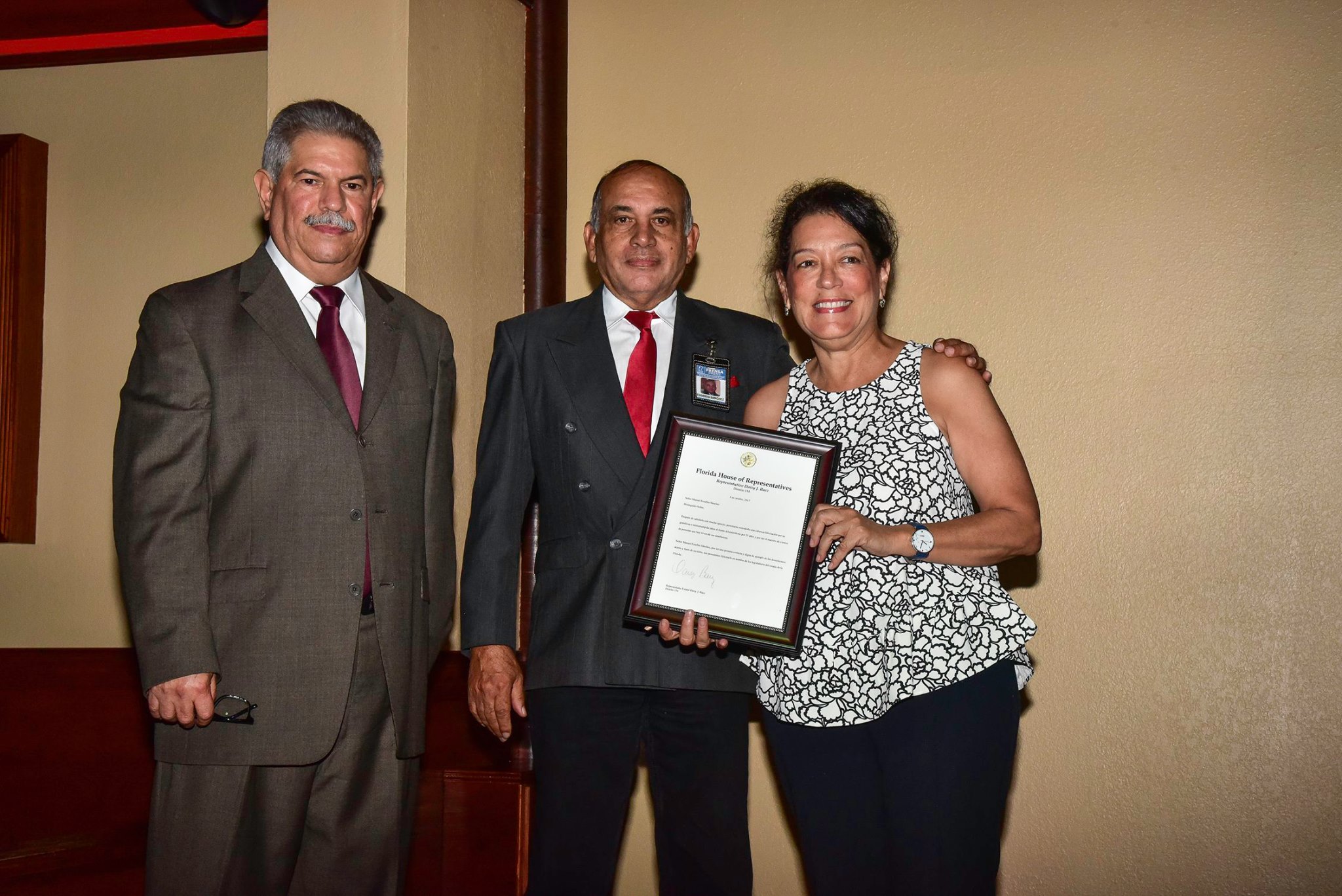 Momento que la representante estatal Daisy Báez reconoce al locutor Sánchez, en la foto Isidro Barros a la izquierda.